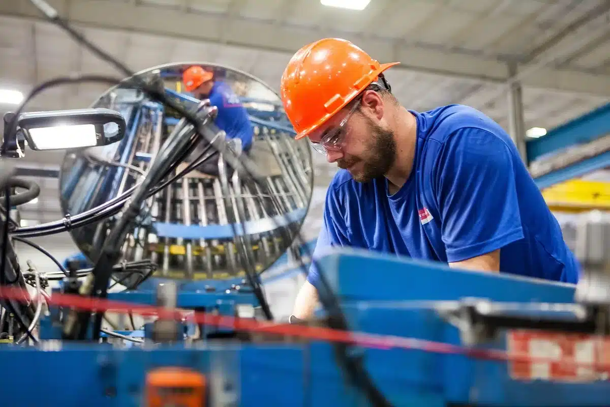 Produktion in einer anonymisierten Fabrikhalle mit Montagebändern und Technik