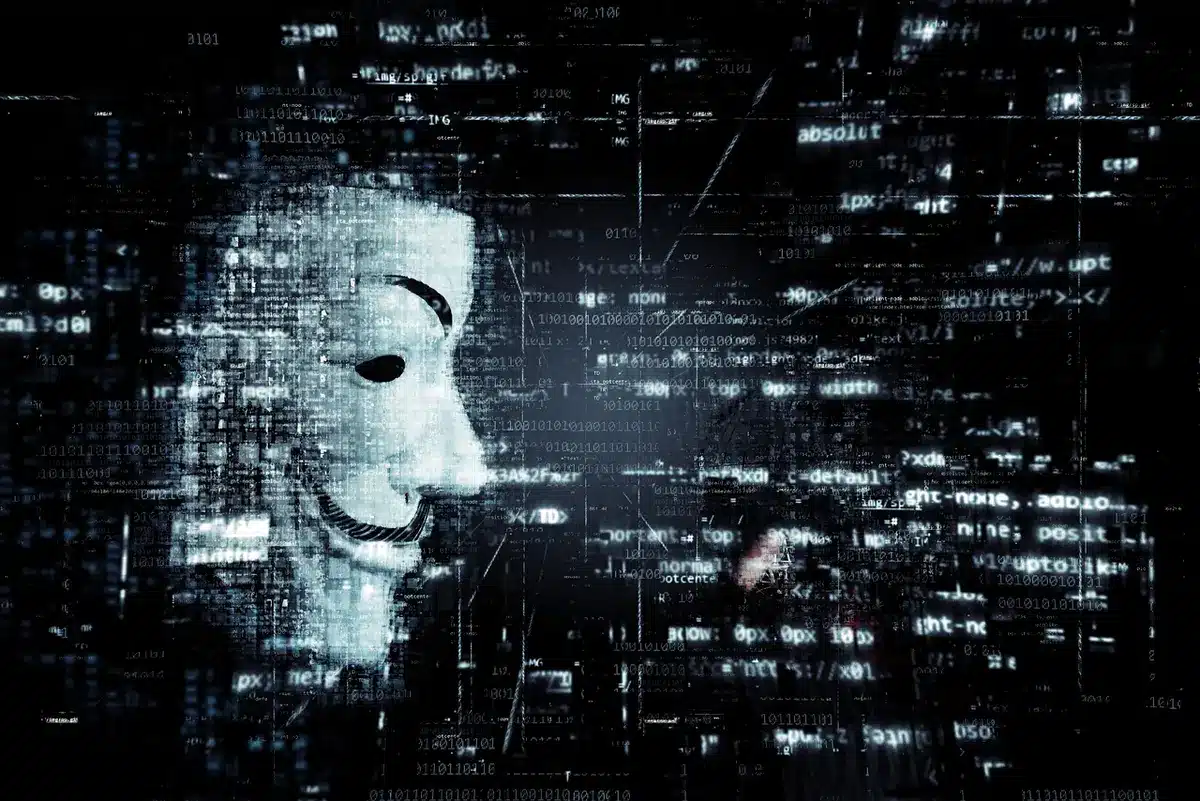 Symbolische Darstellung einer Hackergruppe mit Code auf Bildschirm