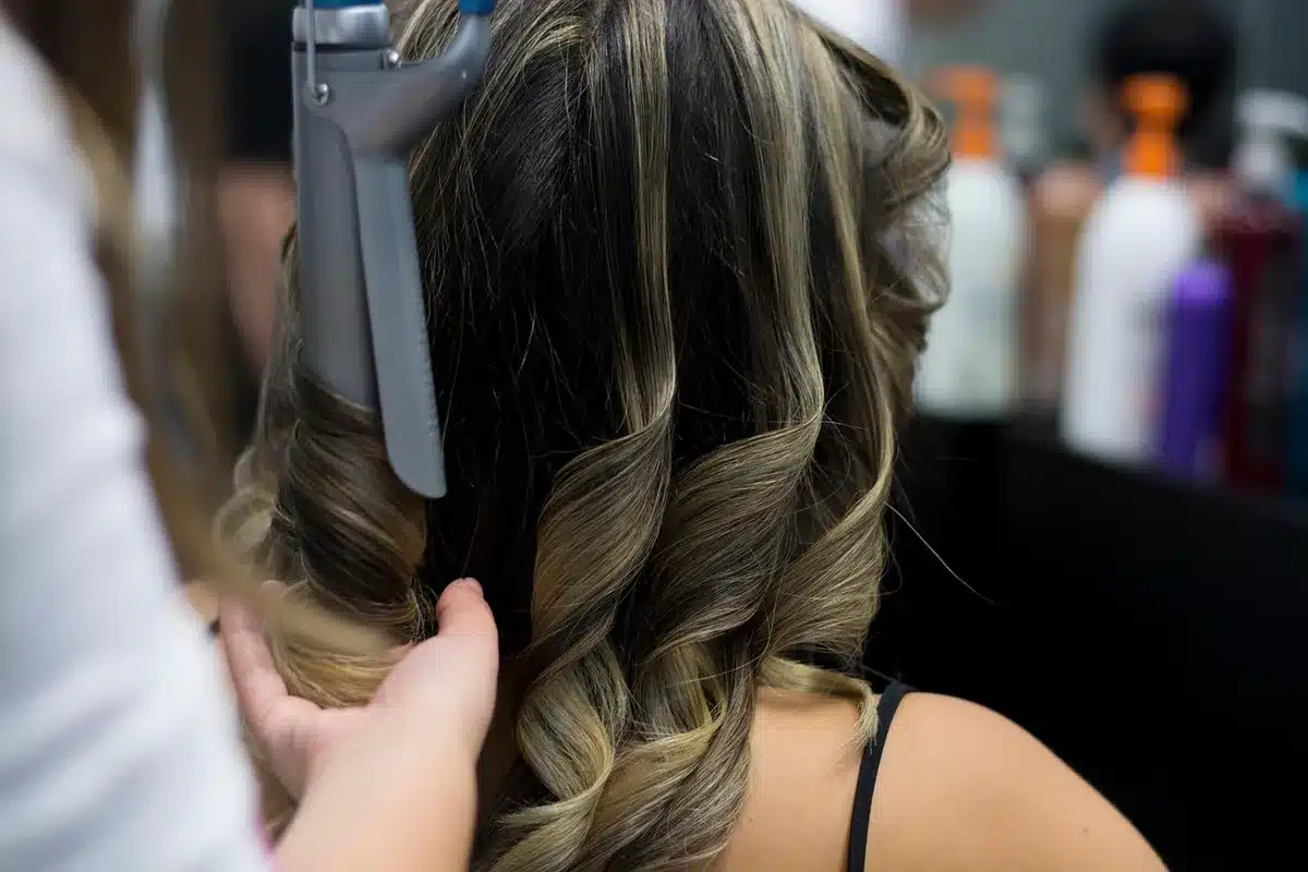 Friseurlehrling beim Haarschnitt im Salon