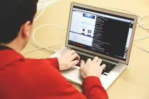 Entwickler arbeitet an mehreren Monitoren mit Code und Ad-Implementierung
