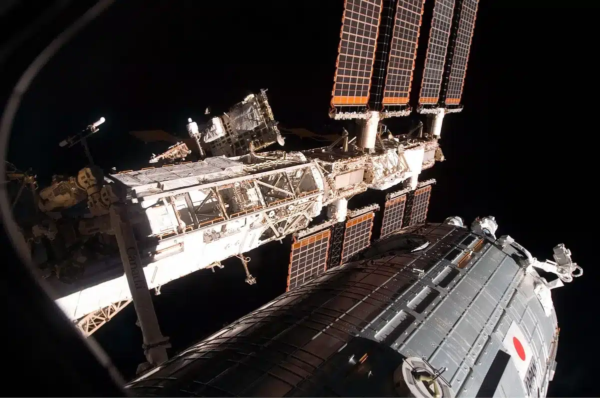 Satellit mit zündenden Triebwerken nahe einem Asteroiden im Orbit