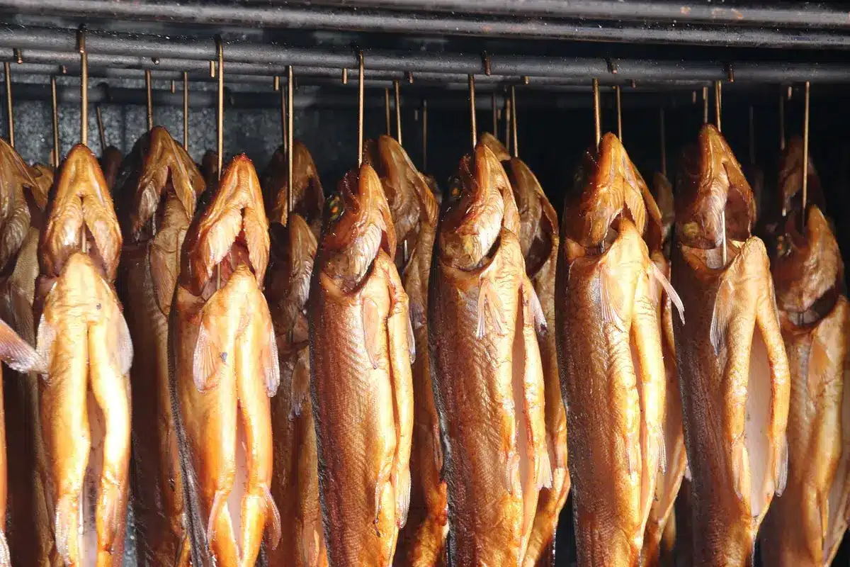 Räucherkammer mit aufgehängten Fleischstücken und traditioneller Ausrüstung