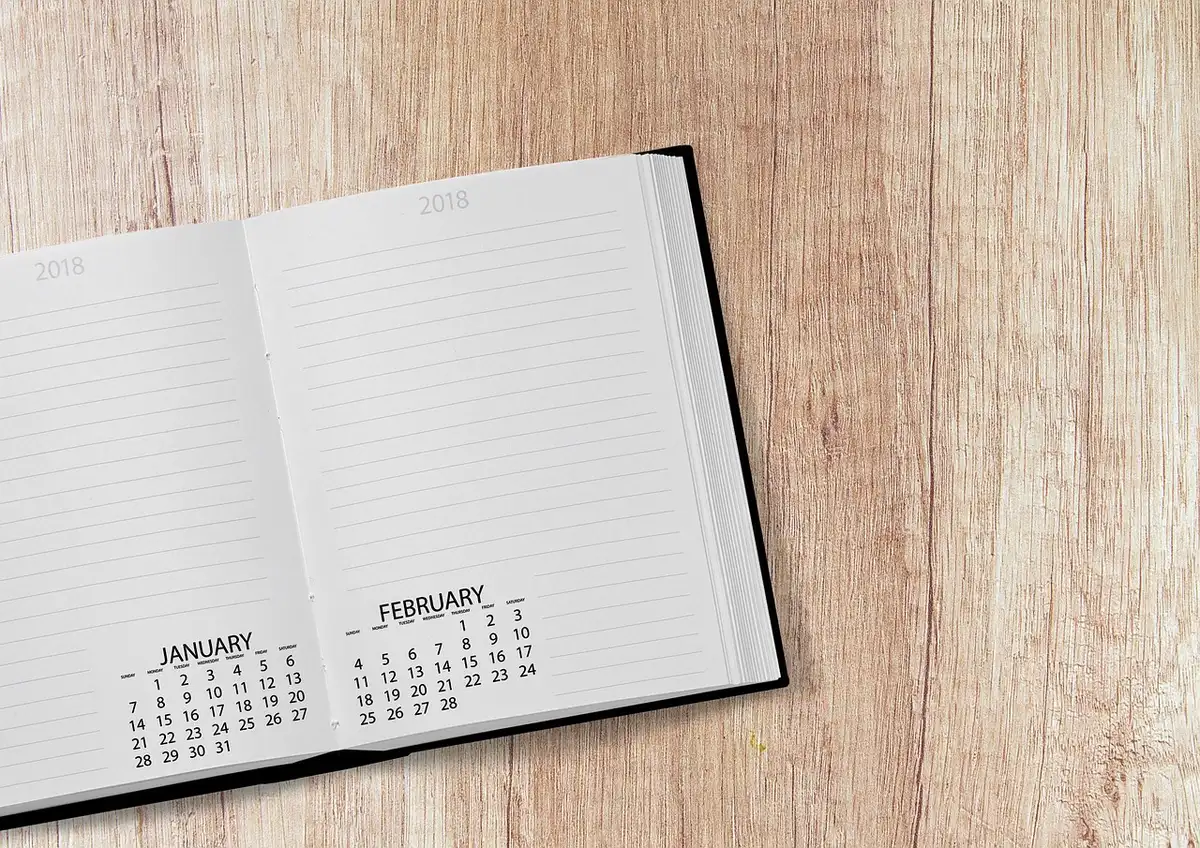 Notizbuch mit eingezeichneter Konferenzagenda und Stift