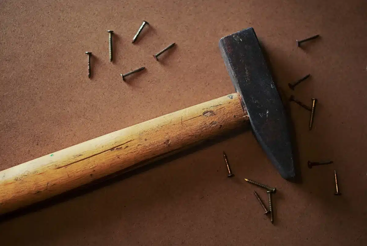 Lehrling in einer Tischlerei arbeitet mit Handwerkzeugen an einem Holzstück
